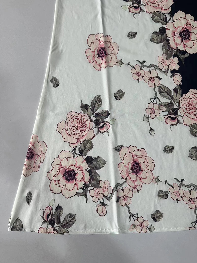 Floral patterned fabric with pink flowers and green leaves on a light background